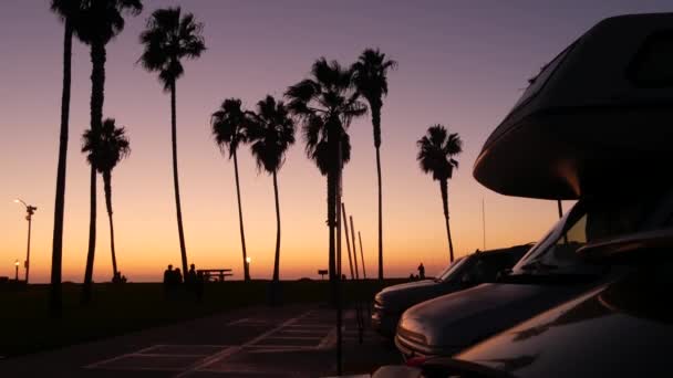 Karavan, yolculuk için karavan, palmiye ağaçları, günbatımında Kaliforniya plajı. — Stok video