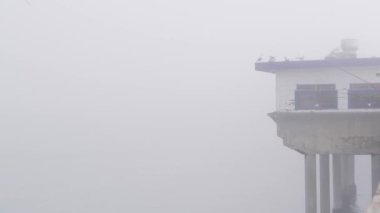 Su yığınları üzerindeki ahşap ev, Ocean Beach rıhtımı, sisli California sahili, ABD.