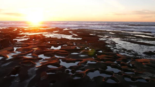 Formación de roca de piscina de marea erosionada en California. Zona intermareal litoral, puesta de sol. — Foto de Stock