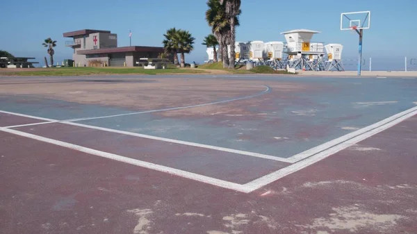 Palmeras y cancha deportiva de baloncesto en la playa, costa de California, EE.UU.. — Foto de Stock