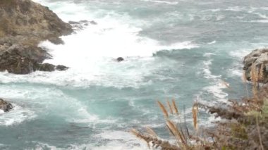 Kayalık okyanus, sisli hava. Dalgalar sahile çarpıyor. Kaliforniya, Big Sur.