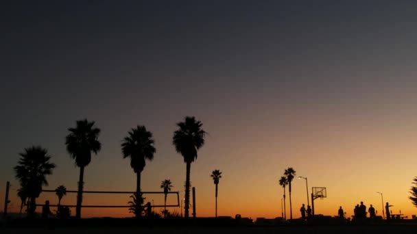 Lidé na basketbalovém hřišti hrají basket. Západ slunce na pláži, Kalifornie — Stock video