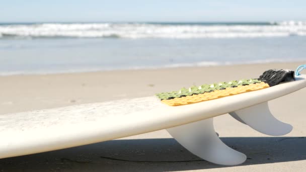 Deska surfingowa do surfowania leżąca na piasku plażowym, wybrzeże Kalifornii, USA. Fale morskie. — Wideo stockowe