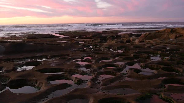 Formación de roca de piscina de marea erosionada en California. Reflejo del cielo atardecer en agua. — Foto de Stock
