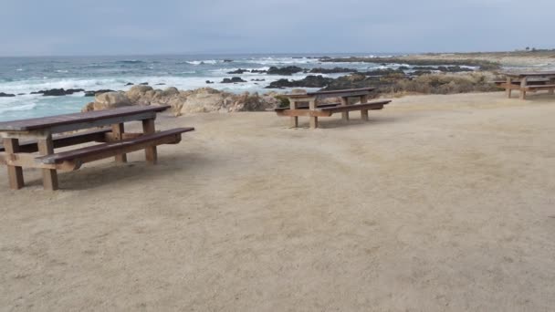 Felsige zerklüftete Meeresküste, Meereswellen, Monterey Kalifornien. Holzbank leer. — Stockvideo