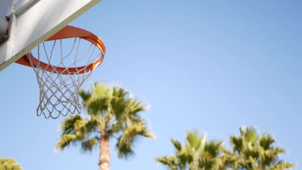Γήπεδο μπάσκετ σε εξωτερικούς χώρους, πορτοκαλί στεφάνι, δίχτυ και backboard για μπάσκετ παιχνίδι. — Αρχείο Βίντεο