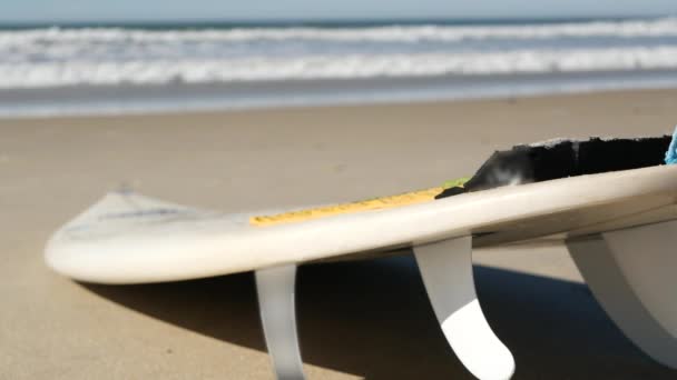 Tabla de surf para practicar surf en la arena de la playa, costa de California, EE.UU. Ondas oceánicas. — Vídeo de stock