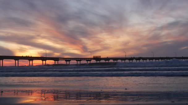 Surfaři surfují na molu. Mořské vlny, lidé a obloha při západu slunce. California — Stock video