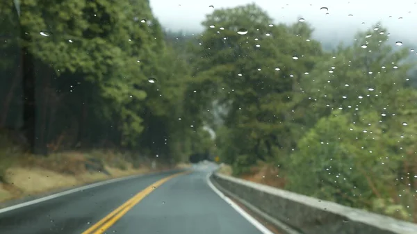 Ploaie picături pe parbriz, mașină de conducere în pădurea Yosemite, Excursie rutieră, California. — Fotografie, imagine de stoc