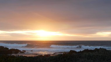 Kayalık okyanus kıyıları, deniz dalgaları, Monterey plajı, California, dramatik günbatımı gökyüzü.