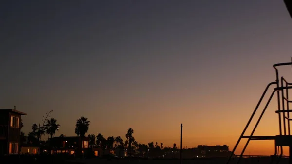 Pálmafák sziluettek a szürkületi égbolton, California Beach, USA. Tengerparti házak — Stock Fotó