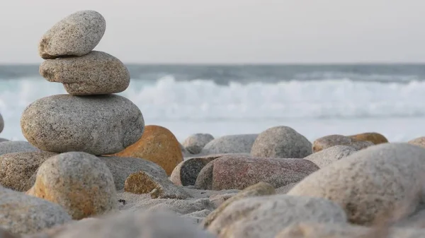 Fels balanciert auf Kiesstrand. Pyramidenstapel aus Steinen, Meeresküste, Meerwasser — Stockfoto
