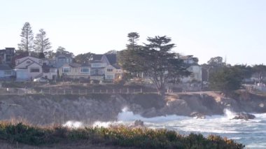 Kayalık okyanus sahilleri, dalgalar çarpıyor, Monterey, California sahil evleri.