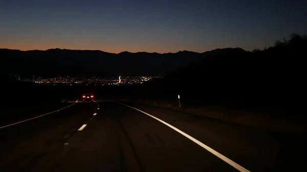 Carro na estrada do vale do deserto à noite, estrada ao entardecer. Viagem de carro nos EUA. — Fotografia de Stock