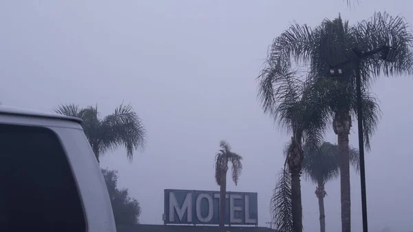 Sign of road motel or hotel, foggy misty weather California, USA. Palm trees. — Stock Photo, Image