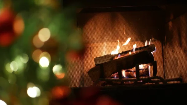 Christmas tree lights by fire in fireplace, New Year or Xmas decoration of pine. — Stock Photo, Image