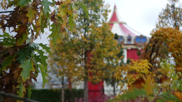 Ročník kolotoč v podzimním parku, retro cirkus nebo veselé jít kolem karuselový stan. — Stock fotografie