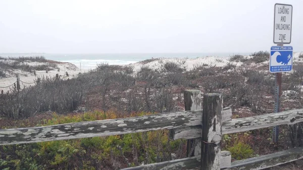 Okyanus kumlu kum tepeleri, Kaliforniya 'nın sisli kıyıları. Sisli yağmurlu hava, soğuk deniz.