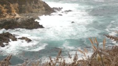 Kayalık okyanus, sisli hava. Dalgalar sahile çarpıyor. Kaliforniya, Big Sur.