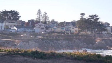 Kayalık okyanus sahilleri, dalgalar çarpıyor, Monterey, California sahil evleri.