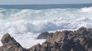 Büyük fırtınalı deniz dalgaları Kaliforniya okyanus kıyısındaki kayalık kayalıklara çarpıyor.