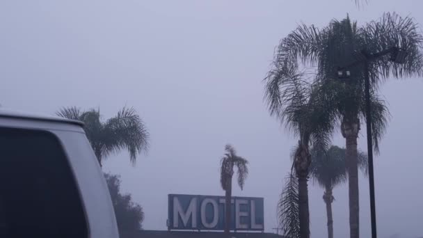 Señal de carretera motel u hotel, neblinoso tiempo brumoso California, EE.UU.. Palmeras. — Vídeos de Stock