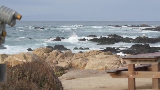 Skaliste skaliste wybrzeże oceanu, fale morskie, Monterey California. Drewniana pusta ławka. — Wideo stockowe