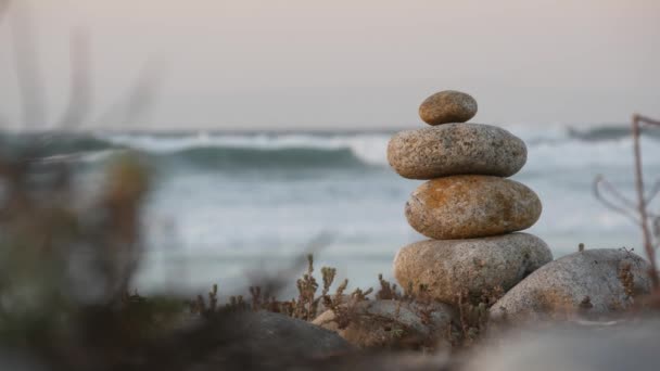 Roccia in equilibrio sulla spiaggia di ghiaia. Piramide pile di pietre, costa oceanica, acqua di mare — Video Stock