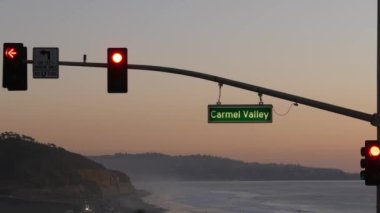 Trafik ışıkları, Pasifik kıyısı otoyolu, California. Alacakaranlıkta okyanus boyunca yolculuk
