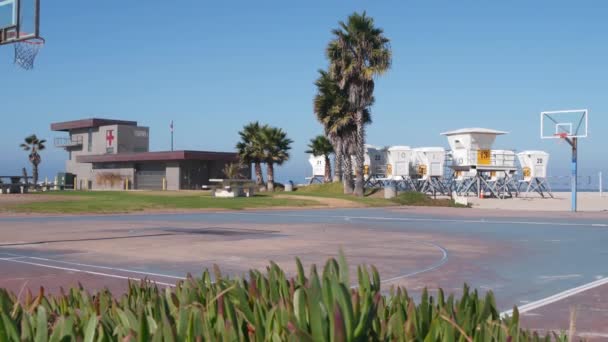 Palmeras y cancha deportiva de baloncesto en la playa, costa de California, EE.UU.. — Vídeo de stock