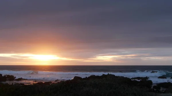 Морські хвилі на узбережжі Скелястого океану, пляж Монтерей Каліфорнія, птахи, що літають, захід сонця — стокове фото