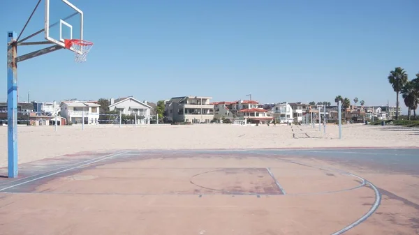 Basketball court with hoop, net and backboard for basket ball game on beach.