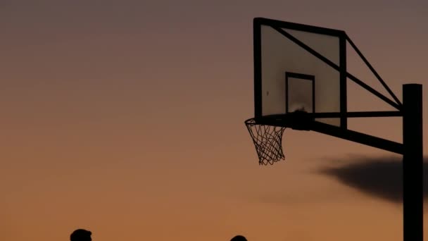 Aro y red para silueta de juego de baloncesto. Los jugadores juegan en cancha de baloncesto. — Vídeo de stock