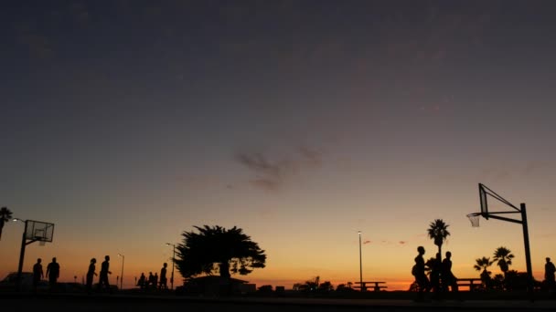 Menschen auf dem Basketballplatz beim Basketballspiel. Sonnenuntergang am Strand, Kalifornien — Stockvideo