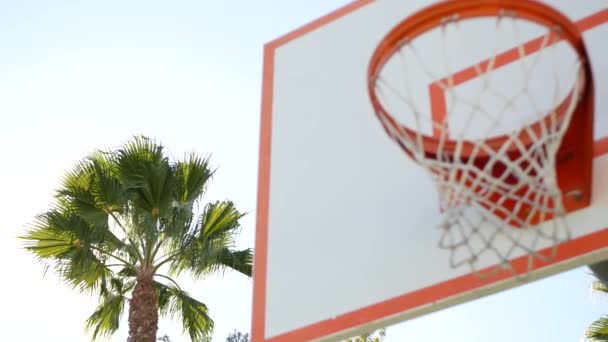 Πορτοκαλί στεφάνι, δίχτυ και ταμπλό για παιχνίδι μπάσκετ. Γήπεδο μπάσκετ στο ύπαιθρο. — Αρχείο Βίντεο
