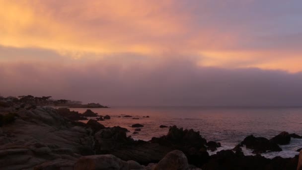 Océano rocoso, playa de mar, costa de California. Rosa púrpura pastel cielo atardecer dramático — Vídeos de Stock