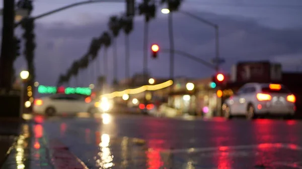 Luces de reflexión sobre la carretera en tiempo lluvioso. Palmeras y lluvias, California. — Foto de Stock
