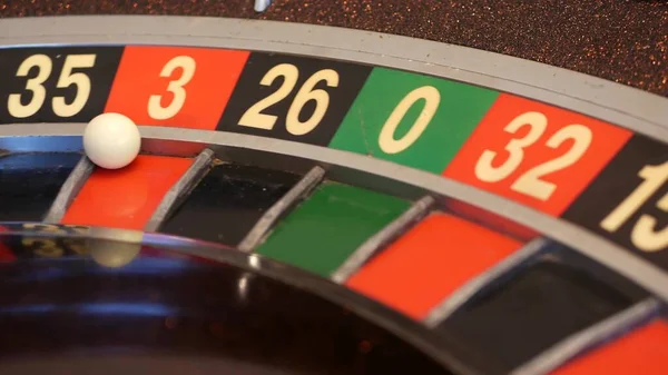 Ball on roulette table in casino. Wheel spinning, turning, rotating. Green zero.