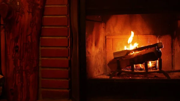 Fogo na lareira de tijolos, queima de lenha, queima de madeira no acolhedor alojamento ou cabine. — Fotografia de Stock