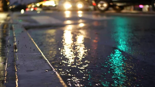 Reflejo de luces, camino en tiempo lluvioso. Gotas de lluvia, asfalto mojado de la calle de la ciudad — Foto de Stock