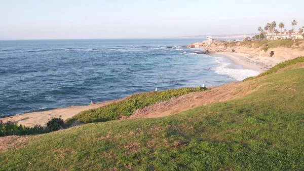 Ocean waves on beach, eroded cliff or bluff, La Jolla, California coast, Verenigde Staten. — Stockfoto