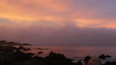 Kayalık okyanus, deniz plajı, California sahili. Pembe mor pastel dramatik günbatımı gökyüzü