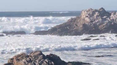 Büyük fırtınalı deniz dalgaları Kaliforniya okyanus kıyısındaki kayalık kayalıklara çarpıyor.
