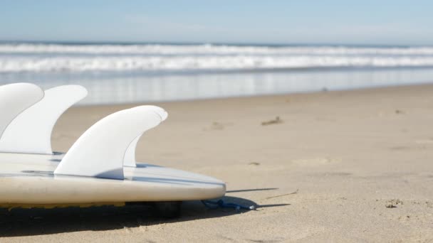 Szörfdeszka szörfözéshez a tengerparti homokon, Kalifornia partjainál, USA. Óceánhullámok. — Stock videók