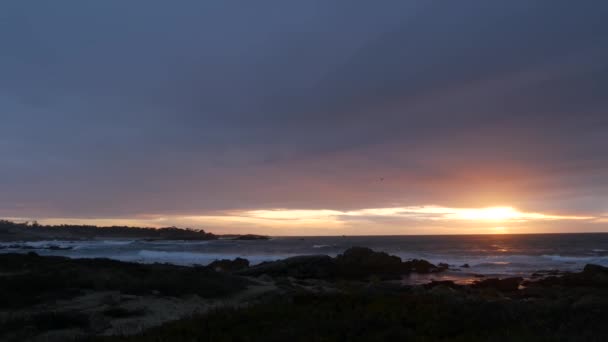 Rocky ocean coast, sea waves, Monterey beach, California, dramatic sunset sky. — Stock Video