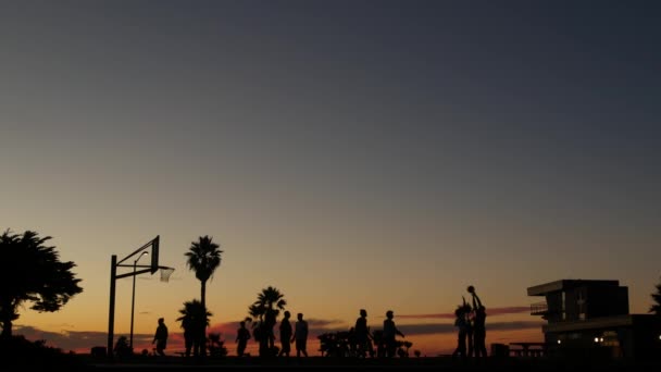 Basketbol sahasında basketbol oynayan oyuncular, günbatımı plajı, California. — Stok video