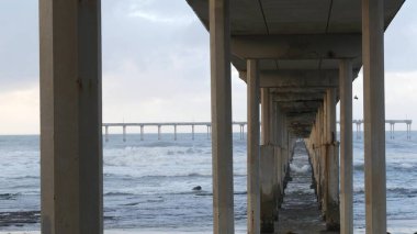 Okyanus sahili rıhtımı yağmurlu havada, deniz dalgaları yağışta, Kaliforniya kıyıları, ABD.