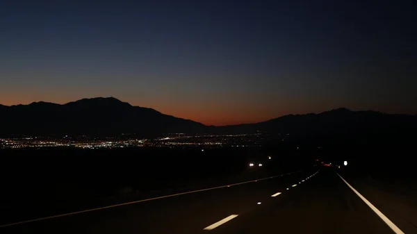 Voiture sur la route de la vallée du désert la nuit, autoroute au crépuscule. Road trip aux États-Unis. — Photo