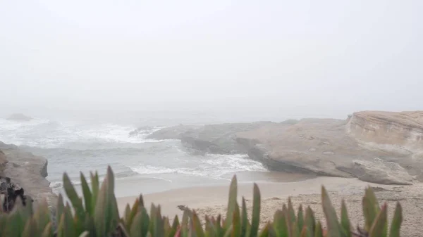 Paisaje marino brumoso, olas que se estrellan en la playa del océano en la niebla, tiempo nublado calma. — Foto de Stock