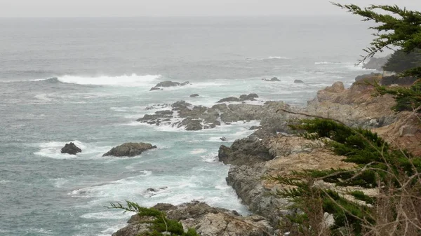 Oceano agitado rochoso, tempo nebuloso. Ondas a cair na praia. Califórnia, Big Sur. — Fotografia de Stock